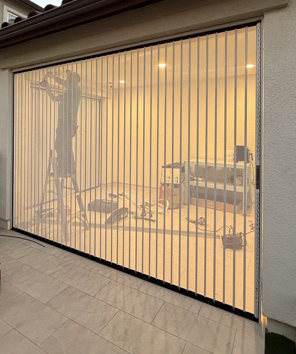 Wide white folding screen closing off a large back-patio opening