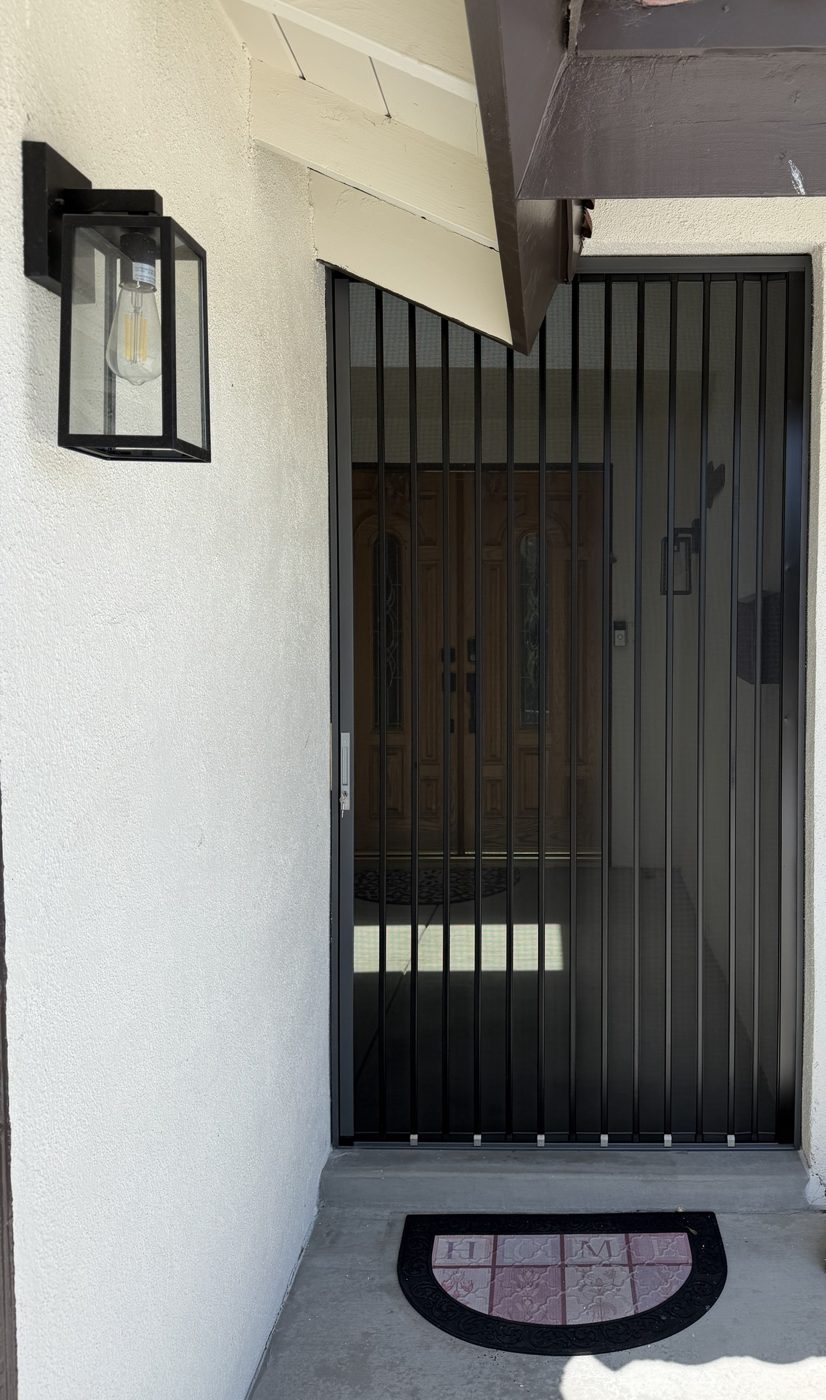 Black folding screen closed across a recessed double front entry