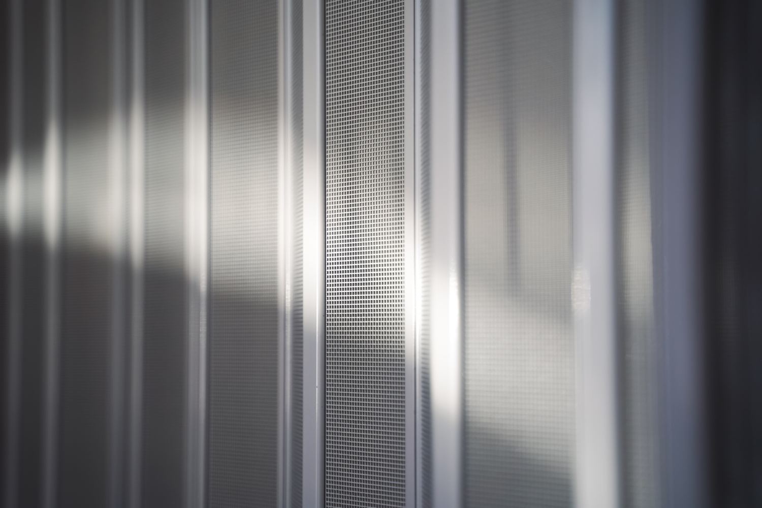 Close-up of the square-weave mesh between slim white pleat strips