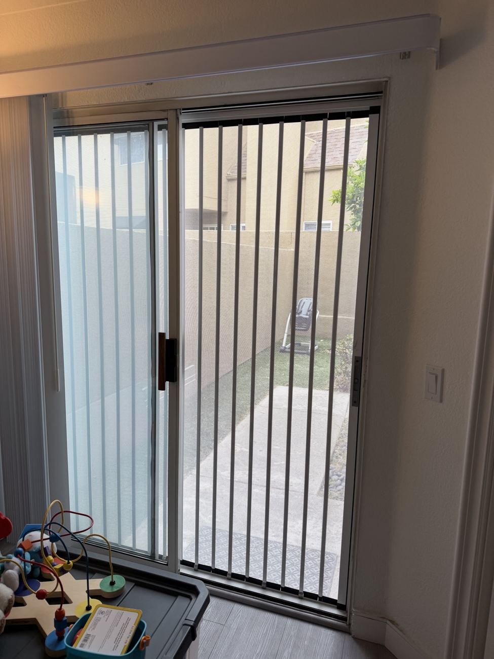 White folding screen in a sliding glass door of a family room, seen from inside