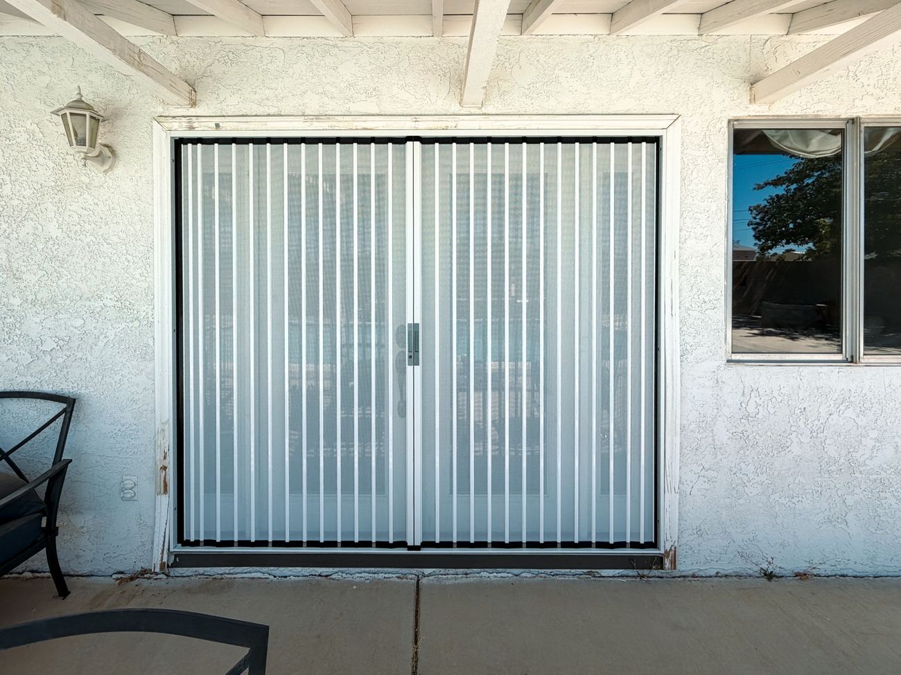 White folding screen across a wide double door opening with a center handle