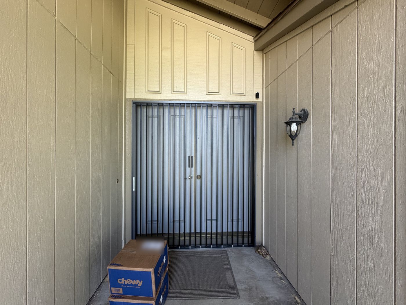 Black folding screen across a pair of gray double front doors