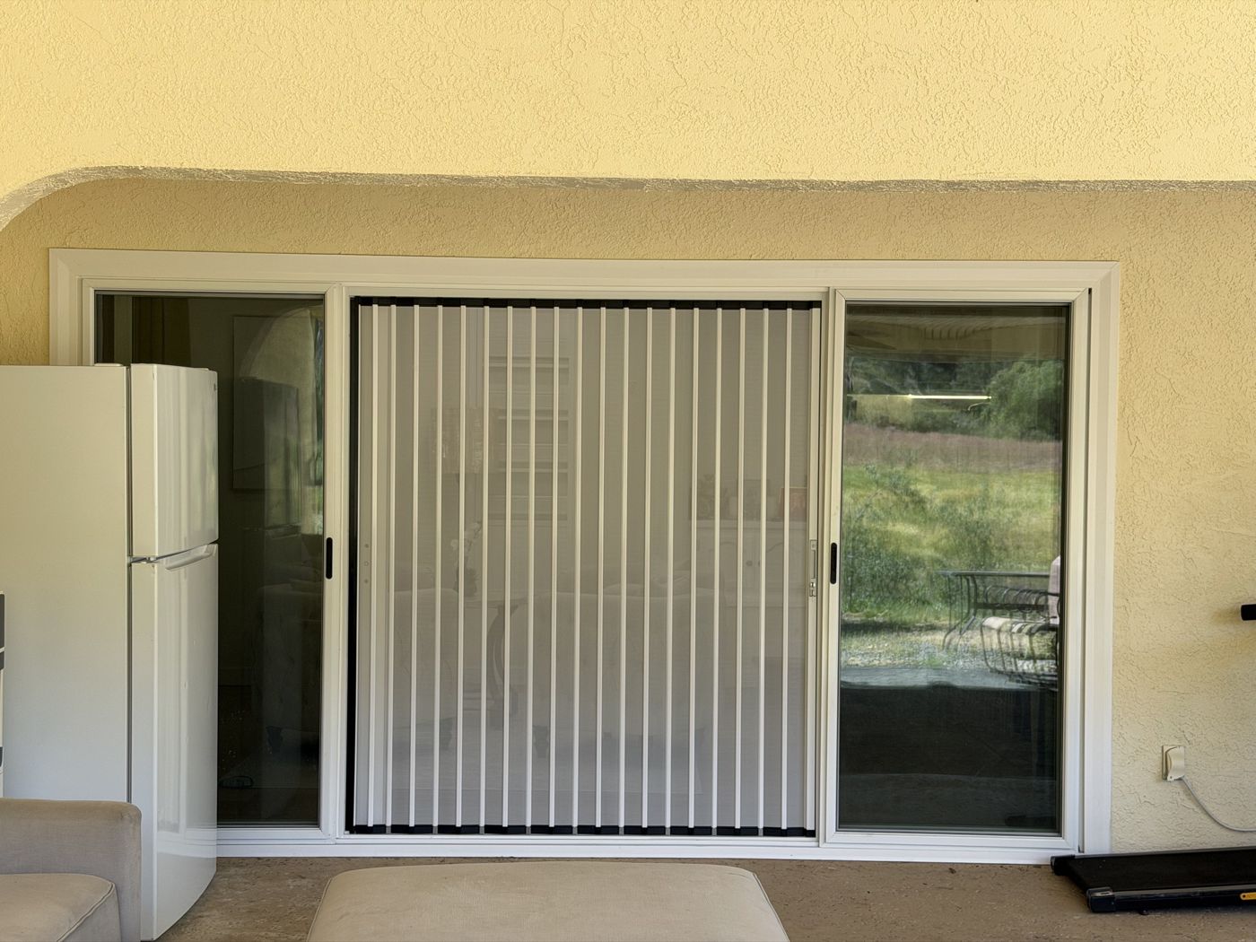White folding screen in a sliding glass door, seen from the patio