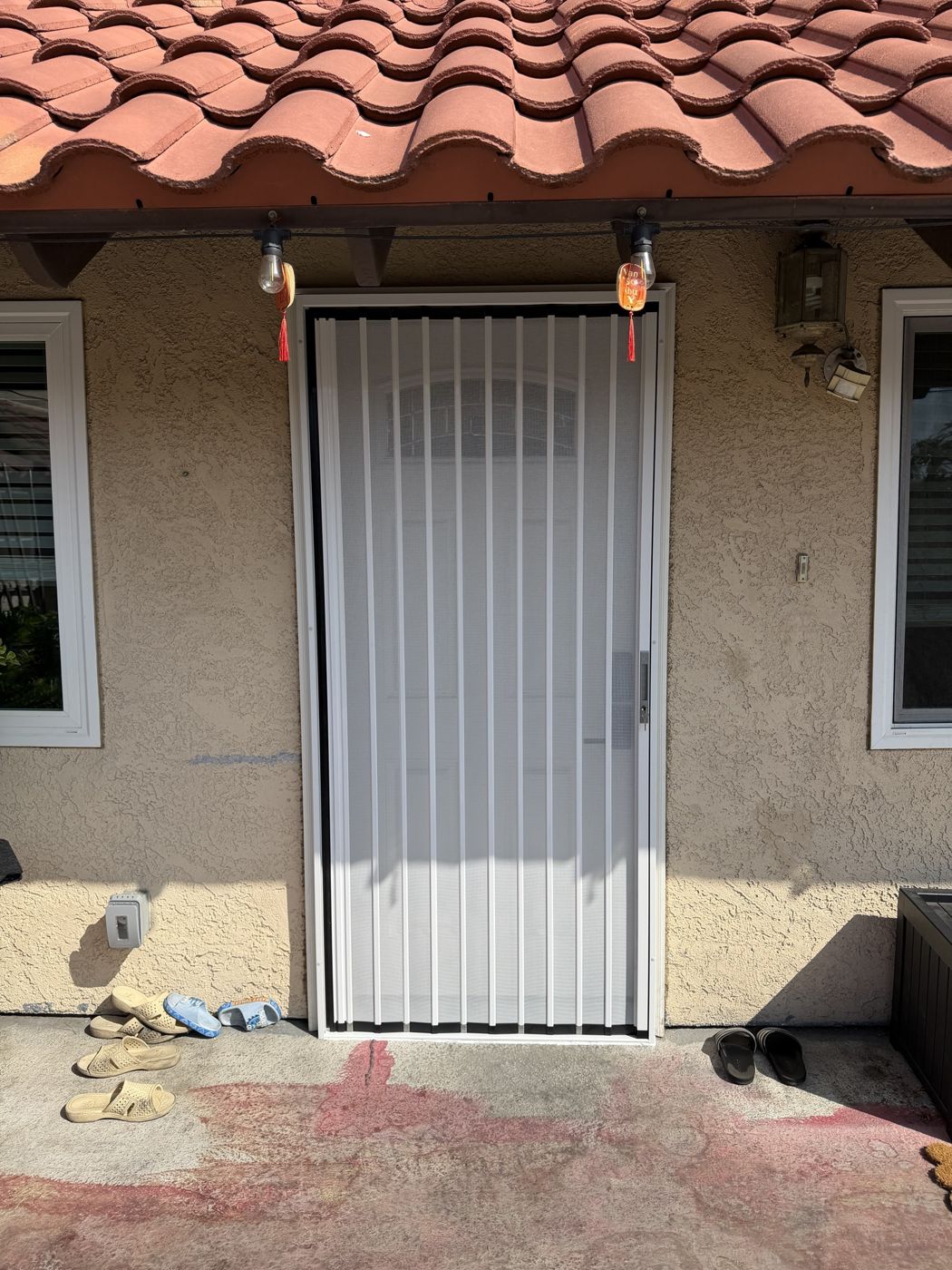 White folding screen on a single door under a clay tile roof